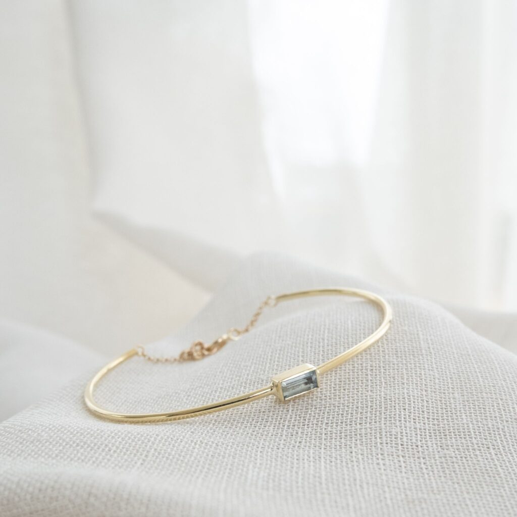 een gouden armband op maat met een aquamrijn in baguette slijpvorm